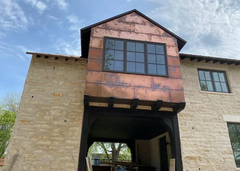 Copper metal panel facade on a stone building for Roof Repair in Bartlett